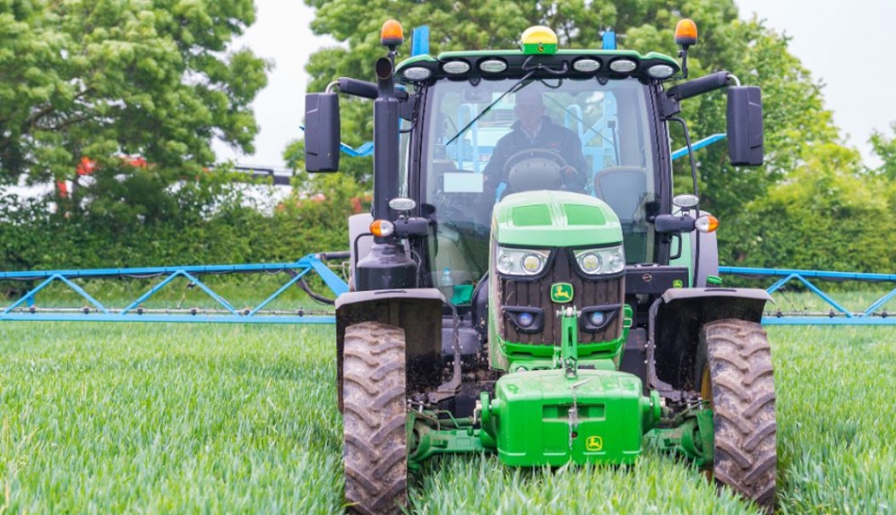 A tractor spraying a cereal crop